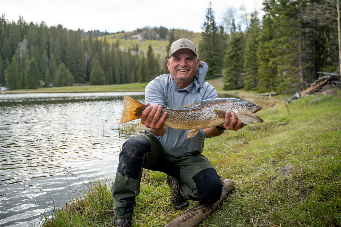 person standing along a riverbank reflecting during a day of fishing