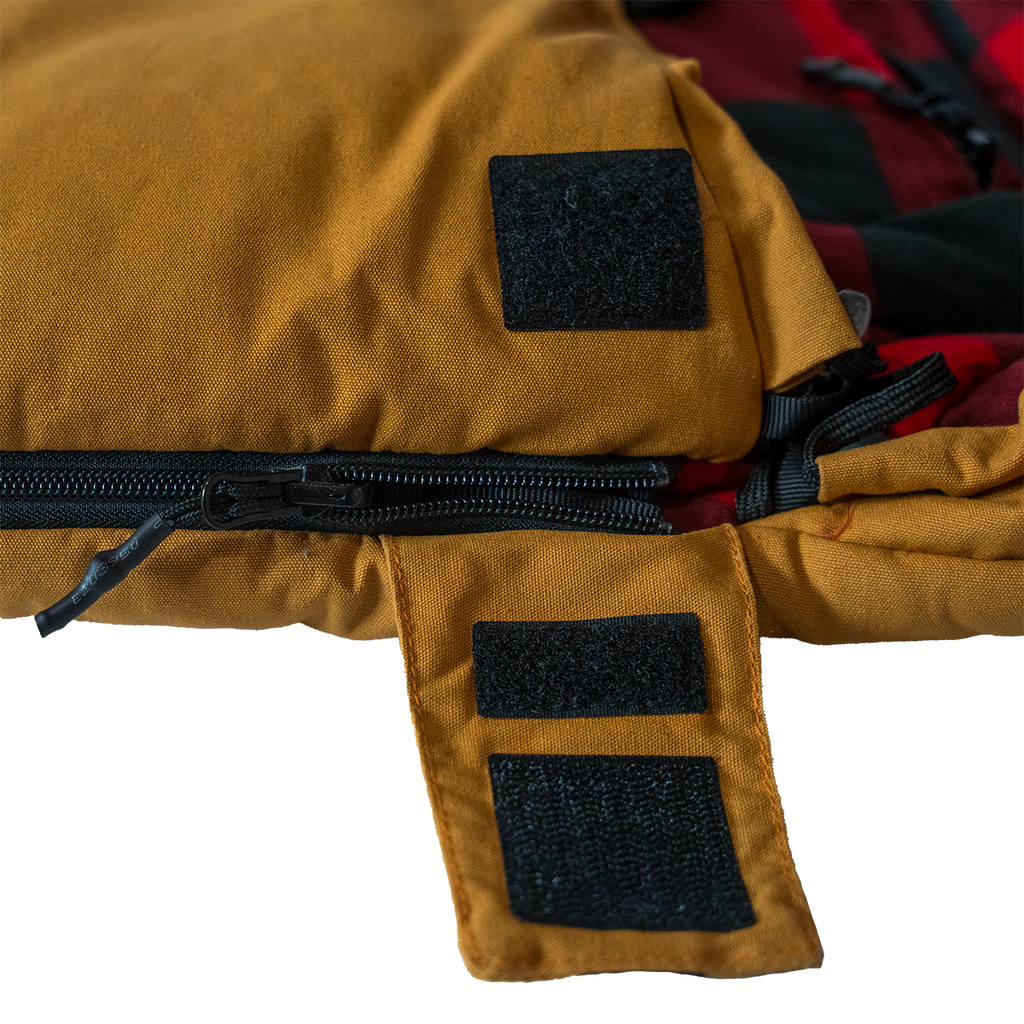 Close up of the Bunker Bag canvas shell showing stitched logo patch and durable fabric construction wiht a zip cover open