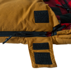 Close up of the Bunker Bag canvas shell showing stitched logo patch and durable fabric construction wiht a zip cover open