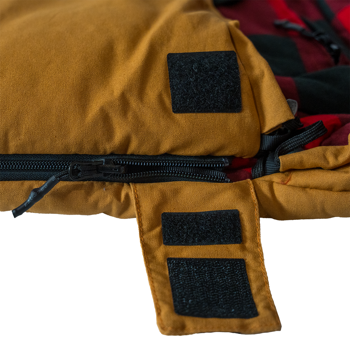 Close up of the Bunker Bag canvas shell showing stitched logo patch and durable fabric construction wiht a zip cover open