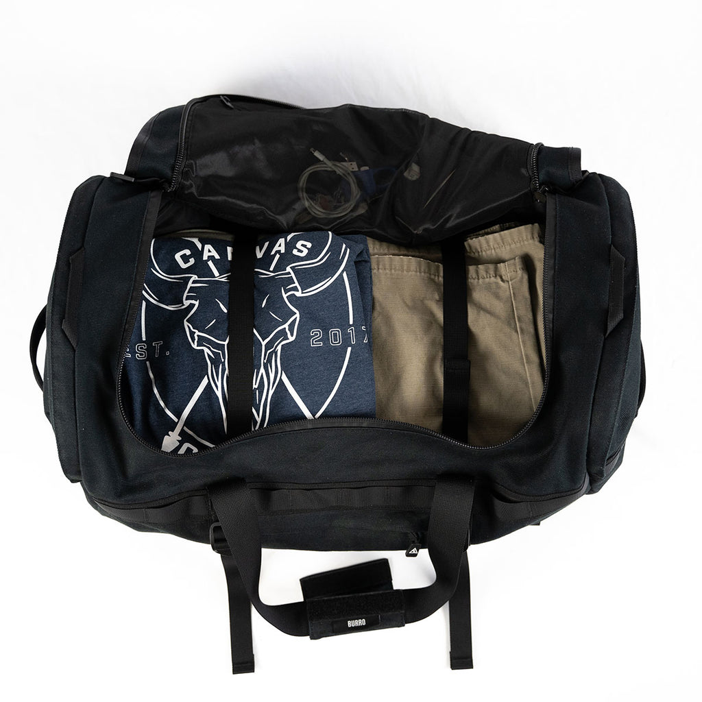 Black Burro duffel open with clothing packed inside main compartment
