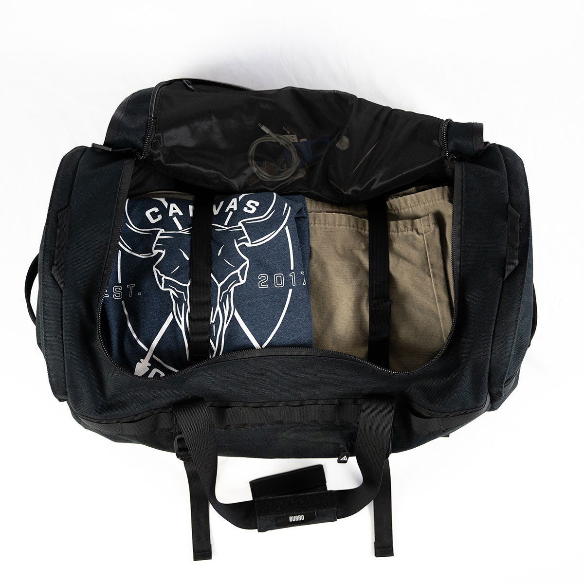 Black Burro duffel open with clothing packed inside main compartment