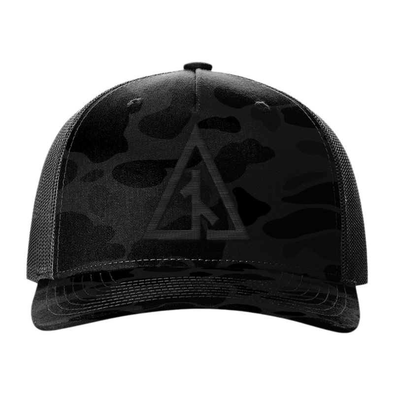 Front view of the Canvas Cutter Darkwater Hat featuring a black camouflage cap with a logo on a blackout five panel trucker design