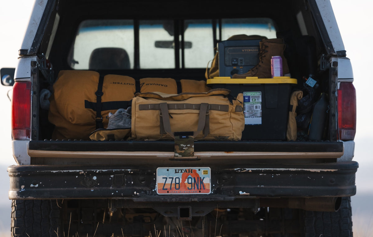 A truck packed with camping gear ideal for hunting, farming, sports including a canvas tent and canvas duffel bag