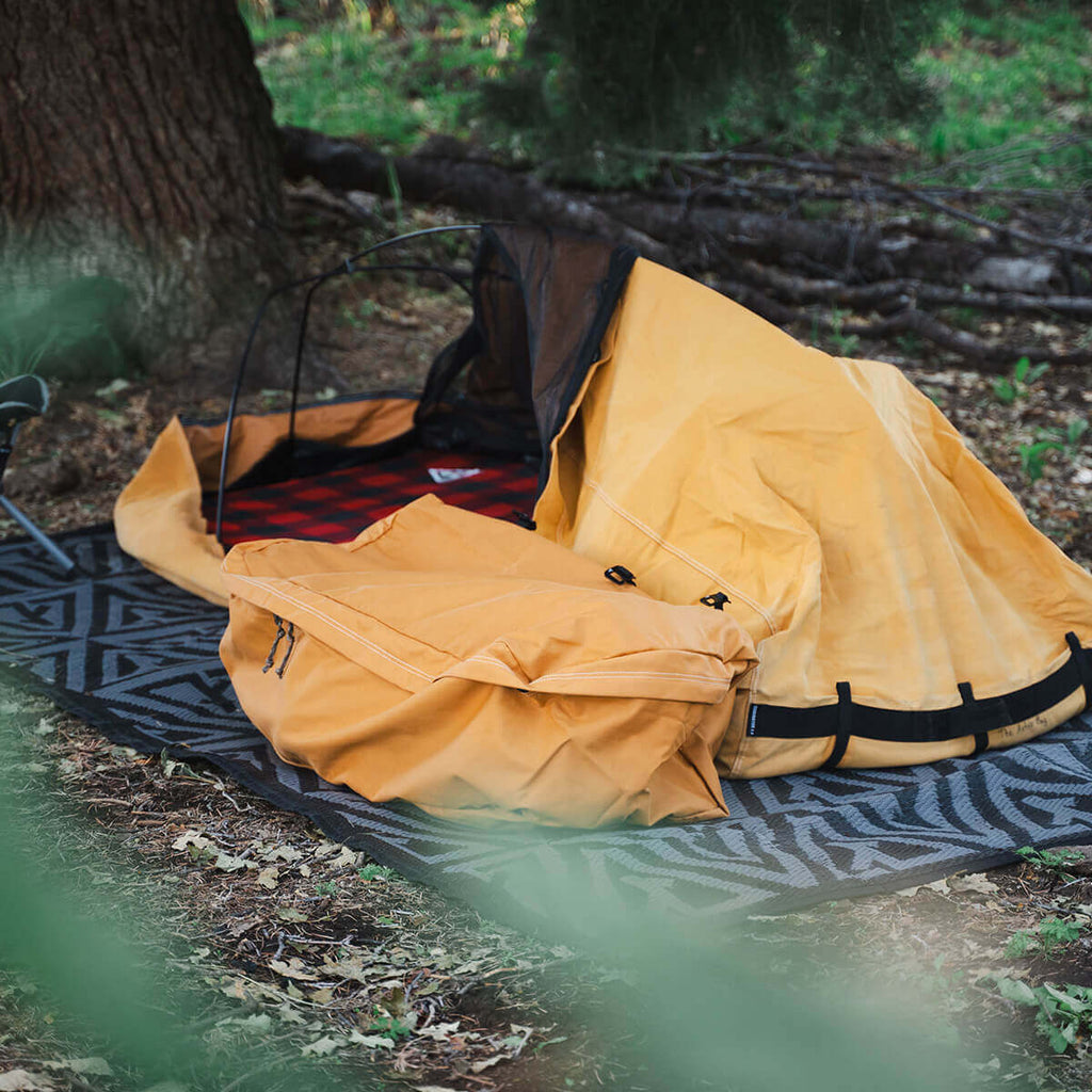 Canvas Cutter Barrier Mat used with a bedroll and gear during camp setup