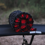 Bedrock Pad rolled up and resting on a cot showing compact packed size for travel