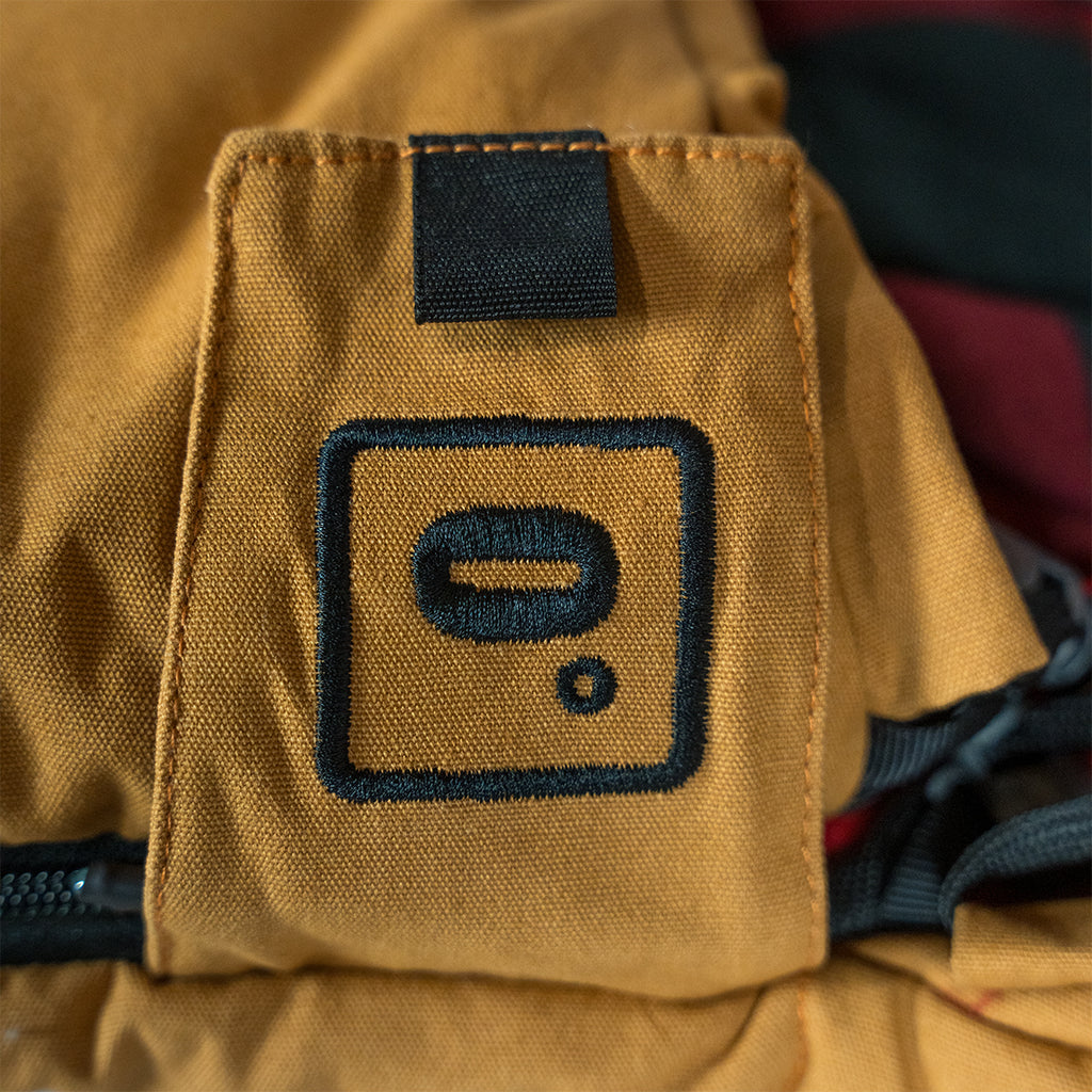 Close up of the Bunker Bag canvas shell showing stitched logo patch and durable fabric construction on the zip cover