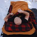 Person sleeping inside the Canvas Cutter Bunker Bag showing interior space and cold weather comfort