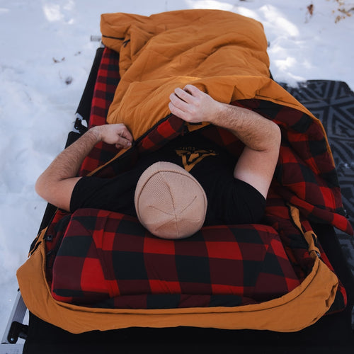 Person sleeping inside the Canvas Cutter Bunker Bag showing interior space and cold weather comfort