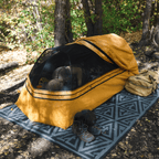 Person laying inside the Dominator 3.0 bedroll with canvas rolled back and bug screen in place for ventilation