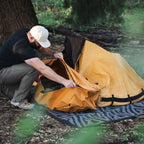 Camper accessing The Locker while the Canvas Cutter bedroll is set up outdoors