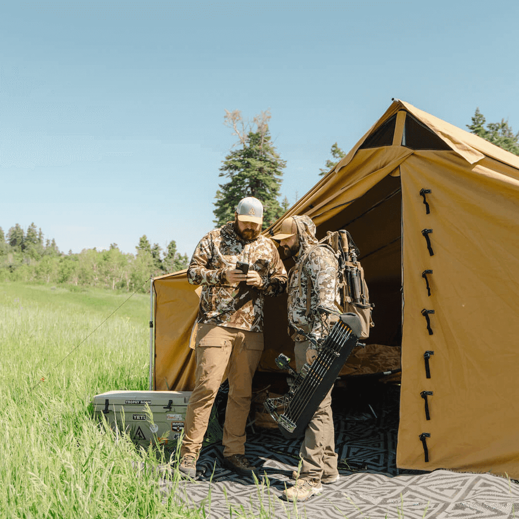 Hunters standing outside a Stronghold modular wall tent at base camp